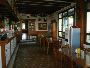 a restaurant with tables and chairs and a refrigerator at Venta Las Delicias in Villanueva del Rosario