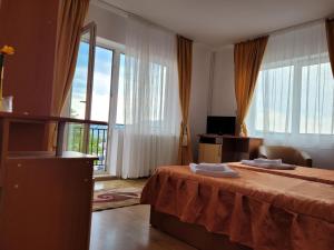 Una habitación de hotel con una cama y grandes ventanales. en La Flori, en Sovata 11 fotos más