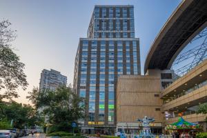 a tall building in the middle of a city at Shanghai Jubelle Boutique Apartment - Subway Lines 8-10-18 - Direct access to the Bund - Free fridge, washing machine, kitchen - Free luggage storage and package collection services in Shanghai