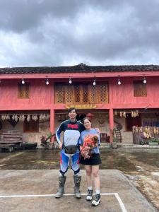 a man and a woman standing in front of a building at Mùa Pửi Lô lô homestay in Mèo Vạc +73 photos