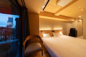 Una habitación de hotel con una cama y una ventana. en WELLSTAY Shinsekai Wakyo, en Osaka