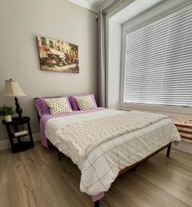 a bedroom with a bed with purple sheets and a window at Richmond home sweet home in Richmond