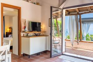 Habitación con TV y puerta corredera de cristal. en holidaysora Taormina - il giardino di Graziella, en Taormina