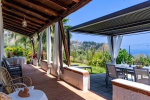 Un patio de una casa con una mesa y sillas. en holidaysora Taormina - il giardino di Graziella, en Taormina