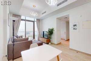uma sala de estar com um sofá e uma mesa em Chic 1BR with Canal View no Dubai