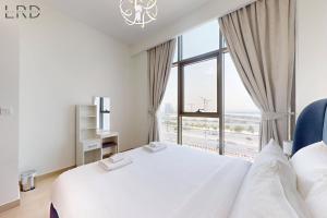 um quarto com uma cama branca e uma janela grande em Chic 1BR with Canal View no Dubai