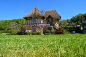 une maison avec une pelouse verte devant elle dans l'établissement Domaine de la Reposée, à Fermaincourt