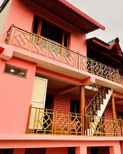a pink building with balconies on the side of it at Holiday home stay in Nainital