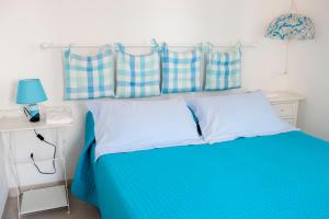 a bedroom with a blue bed with two pillows at Masseria Il Frantoio in Ostuni