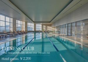 a large swimming pool with chairs in a building at Grand Nikko Tokyo Daiba in Tokyo