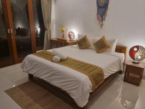 a bedroom with a bed with white sheets and pillows at Umah Dewi Private Villa in Ubud +9 photos