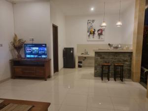 a living room with a television and a fireplace at Umah Dewi Private Villa in Ubud