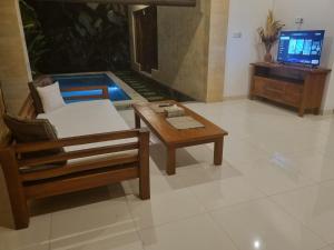 a living room with a couch and a coffee table at Umah Dewi Private Villa in Ubud