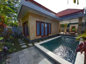 a house with a swimming pool in front of it at Umah Dewi Private Villa in Ubud