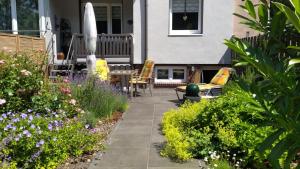 a patio with chairs and flowers on a house at Exclusives 110m2 Ferienhaus Inge mit Garten in Wilhelmshaven