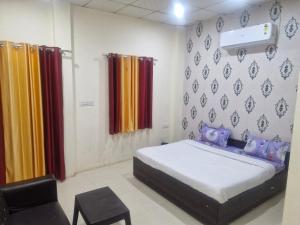 a bedroom with a bed and a chair in it at SAMURAI farm & RESORT in Jaipur