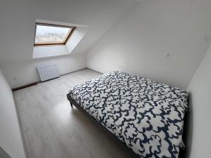 a bedroom with a black and white bed with a window at L'Horizon Silencieux Loft in Lucquy