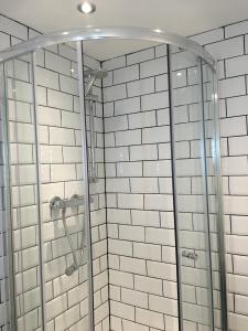 a shower with white subway tiles in a bathroom at Happy Return Hotel in Blackpool