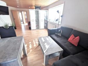 a living room with a black couch and a table at BodenSEE Apartment "La Musica" in Meckenbeuren +31 photos