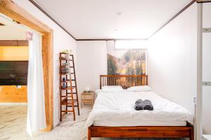 ein Schlafzimmer mit einem Bett mit zwei Schuhen drauf in der Unterkunft 5BR Family House, Myeongdong 7 minutes, Gwanghwamun 10 minutes, Namsan view, Patio in Seoul + 19 Fotos