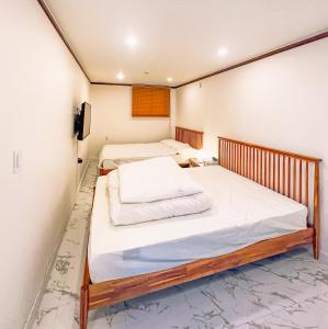 2 Einzelbetten in einem Zimmer mit einer Wand in der Unterkunft 5BR Family House, Myeongdong 7 minutes, Gwanghwamun 10 minutes, Namsan view, Patio in Seoul