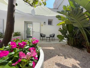 a patio with flowers and a table and chairs at LIMU casa vacanze in Lampedusa