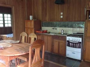 eine Küche mit einem Tisch und einem Herd Top-Backofen in der Unterkunft Casa Ediana in Trindade