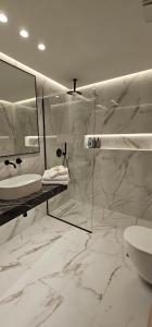 ein Badezimmer mit Waschbecken, Toilette und Spiegel in der Unterkunft S & E luxury city residences in Rhodos (Stadt)