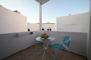 a table with two chairs and a bowl of fruit on it at Casaprimavera in Katapola