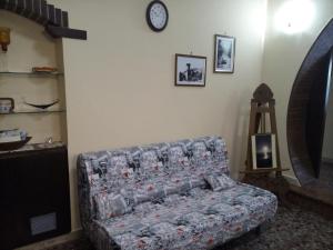 uma sala de estar com um sofá e um relógio na parede em B&B A Casa Di Nonna em Fondi
