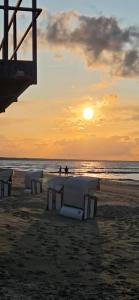a group of tables on a beach at sunset at Fewo Seepferdchen in Zempin +19 photos