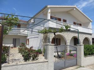 a house with a glass gate in front of it at Filipovic Apartments with Pool in Biograd na Moru