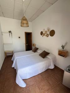 a bedroom with a white bed in a room at Hostal la Tarayuela in Barbate +10 photos