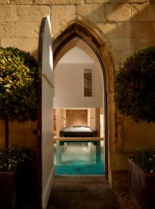 an archway leading into a bedroom with a swimming pool at The Royal Crescent Hotel & Spa in Bath