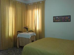 a bedroom with a table with a vase of flowers at Hotel Tarabaralla in Borgo a Buggiano