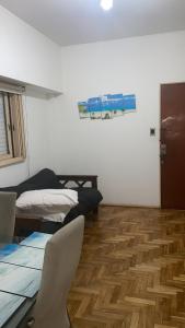 Habitación con 2 camas y suelo de madera. en 2 ambientes fundacion hospitalaria, en Buenos Aires