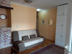 a living room with a couch and a brick wall at Exit NS in Novi Sad