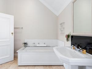 a white bathroom with a tub and a sink at Winelands Golf Lodges 2 in Stellenbosch