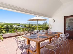 a dining room with a wooden table and chairs at Winelands Golf Lodges 2 in Stellenbosch