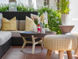 a patio with a couch and a table and chairs at Winelands Golf Lodges 2 in Stellenbosch