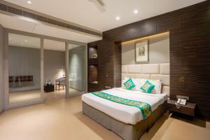 a bedroom with a large bed in a room at Treebo Premium Niraali Executive, Hinjewadi in Pune +42 photos