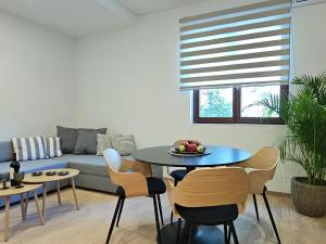 ein Wohnzimmer mit Tisch, Stühlen und Sofa in der Unterkunft S & E luxury city residences in Rhodos (Stadt) + 11 Fotos
