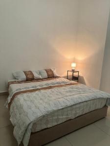 a bedroom with a large bed with a white wall at Green Tree Homestay in Miri