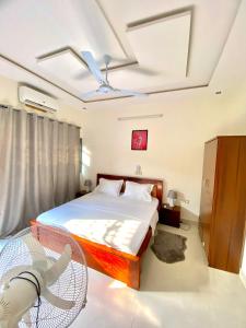 a bedroom with a bed and a fan at Résidence Sekandji in Agbato