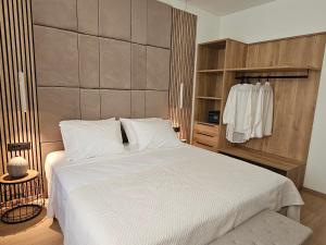 ein Schlafzimmer mit einem großen weißen Bett und einem Schrank in der Unterkunft S & E luxury city residences in Rhodos (Stadt)