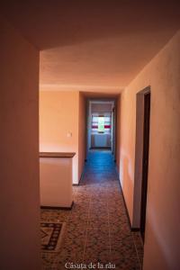 an empty hallway with a hallway leading to a door at Căsuța de la râu 