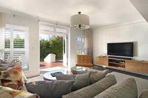 a living room with a couch and a flat screen tv at Winelands Golf Lodges 3 in Stellenbosch
