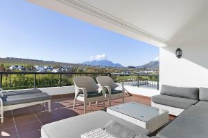 a living room with a couch and chairs on a balcony at Winelands Golf Lodges 3 in Stellenbosch