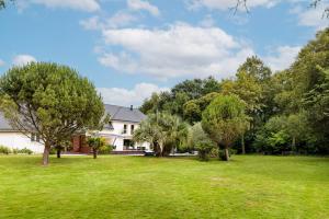 ein Haus mit einem großen Garten mit Bäumen in der Unterkunft Villa Markaly in Vigneux-de-Bretagne