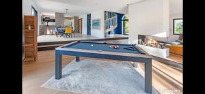ein Wohnzimmer mit einem Billardtisch und ein Schlafzimmer in der Unterkunft Villa Markaly in Vigneux-de-Bretagne